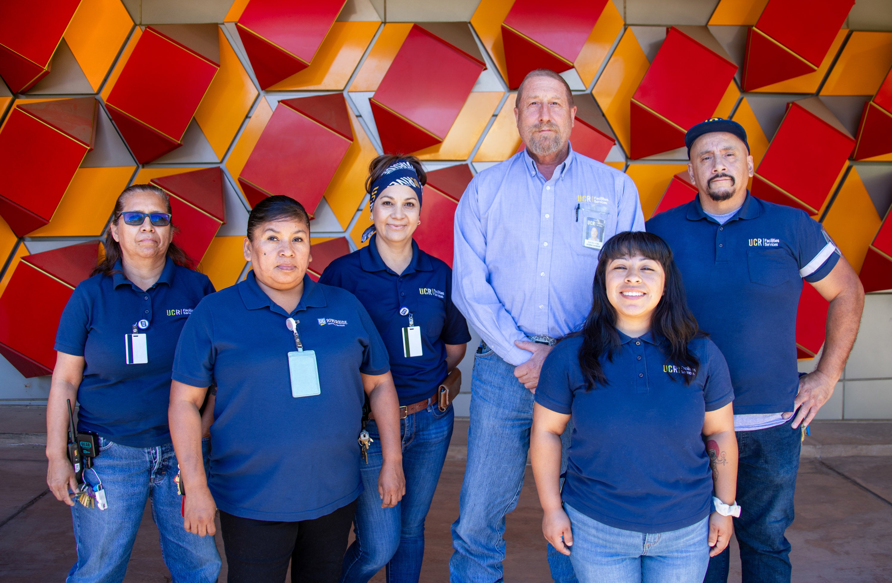 Custodians standing in front of the Genomics building