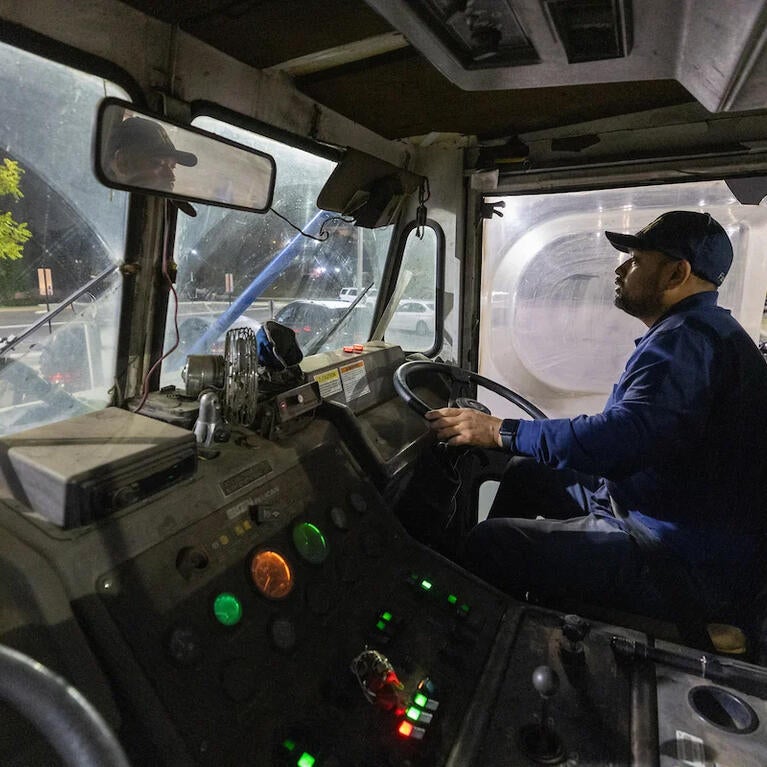 Man driving a street sweeper at night