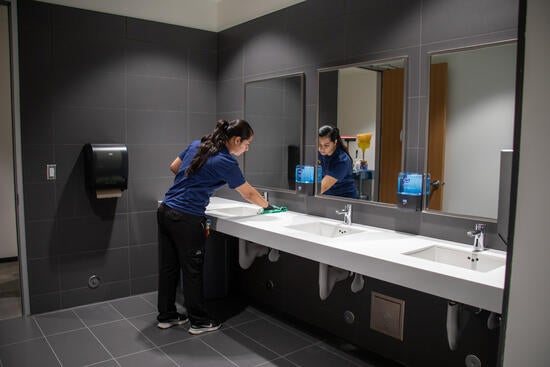 Custodian cleaning SOM ED II restroom